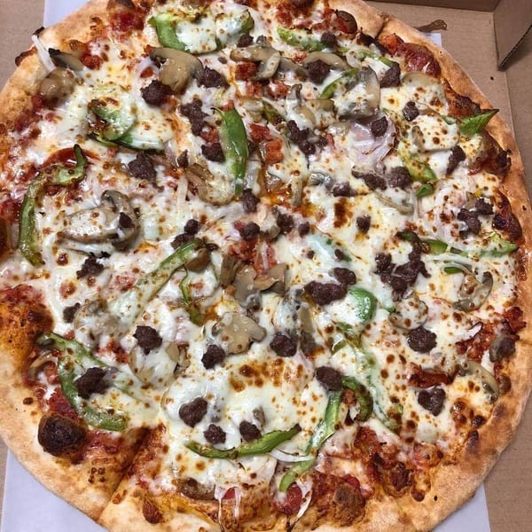 Timo's Pizza with green peppers, mushrooms, onions, and ground meat, in a pizza box.